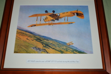 Brown timber frame containing print of aircraft flying upside down