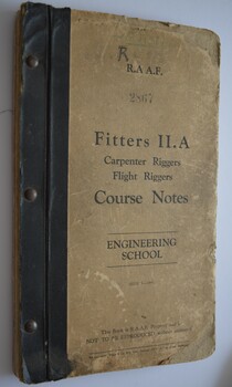Book has black binding with metal studs.  Cover is  off-white with black writing.