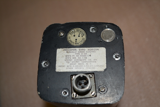 Aircraft Gyro Horizon Indicator - silver metal instrument comprising of multiple parts housed in black metal oblong unit.