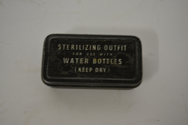 Small black oblong metal tin with white writing on lid.