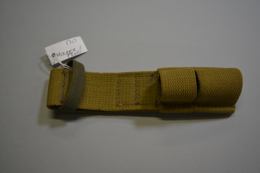 Pale khaki canvas type material bayonet holder, also known as a Frog.  Has a large darker khaki loop at the top and two smaller canvas loops at the bottom.