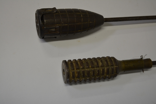 Long metal rod with round grenade attached at one end.