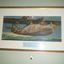 Gold painted embossed metal frame containing watercolour painting of plane on water