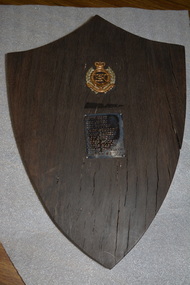 Black painted cylindrical instrument with glass face .  There is a side cutout containing  metal parts .