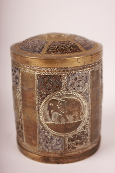 Round metal container with fitted lid ornately engraved with elephants