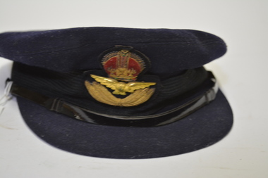 Dark blue felt RAAF Officer’s hat with emblem/crown above wings at front above peak.
