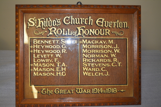 Carved timber frame and mounting with 16 names in gold coloured paint listed in two columns.