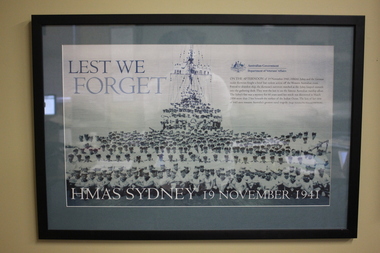 Black plastic frame with grey mount containing poster/photograph of Navy crew on ship and in foreground. 