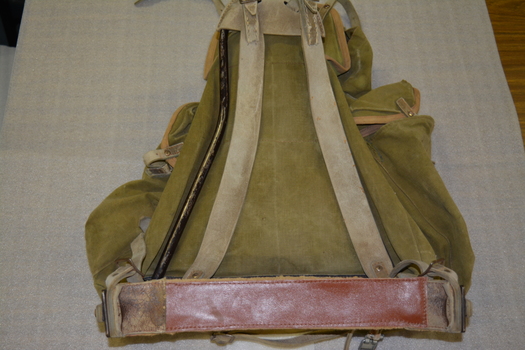 Khaki canvas bag with large pocket and two side pockets - backpack on a metal triangular frame with three leather straps