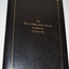 Black leather bound folder with gold coloured writing in centre front of border.  Folder contains a tribute document and photograph of soldier.