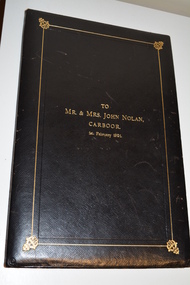Black leather bound folder with gold coloured writing in centre front of border.  Folder contains a tribute document and photograph of soldier.