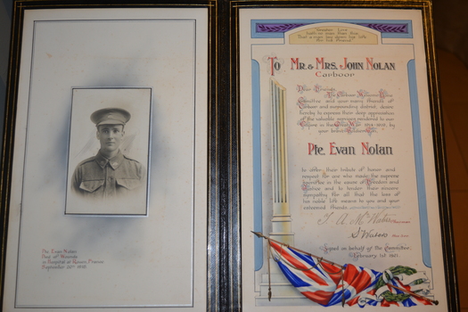 Black leather bound folder with gold coloured writing in centre front of border.  Folder contains a tribute document and photograph of soldier.