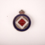Round bronze and enamel badge badge with blue circular border enclosing a white and red diamond. Crown on top.