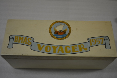 Cream painted wooden box with metal hinges.  There is an inscription and ship on the lid and autographs written in ink on the underside of the lid.   