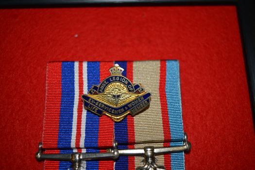 Gold coloured metal and blue badge with crown on top