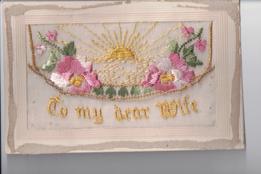 White rectangular postcard with embroidered pink flower, green foliate and yellow rising sun decoration on front.  