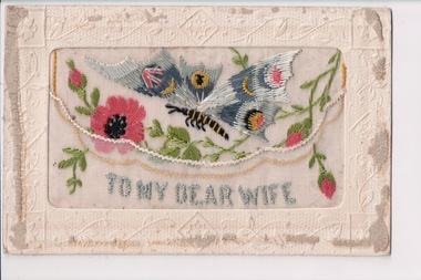 White rectangular postcard with embroidered pink flowers, green foliate and blue winged butterfly decoration on front.  