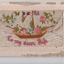 White rectangular postcard with embroidered sailing boat with flying french flag and union jack.  Also pink, blue flowers and green foliate decoration on front. 