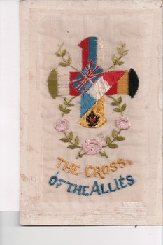 White rectangular postcard (portrait orientation) with embroidered cross representing flags and colours of different countries.  Flower and foliate decoration beneath.  