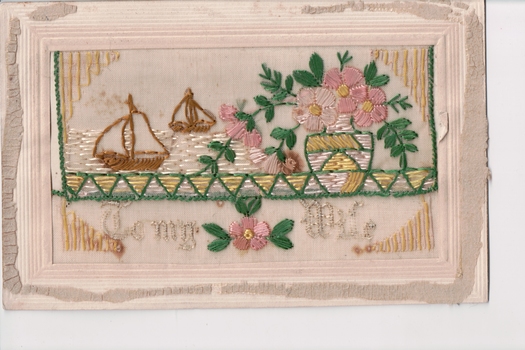 White rectangular postcard with embroidered scene depicting two brown sail boats and vase of pink flowers.  