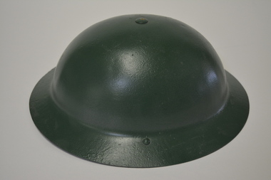 Metal helmet which has been painted dark green.  