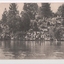 Black and white postcard of steep bank with trees leading down to wide river