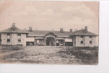 Black and white postcard of long  two story building 
