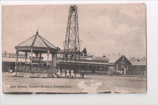 Black and white postcard of bandstand and hotel in background