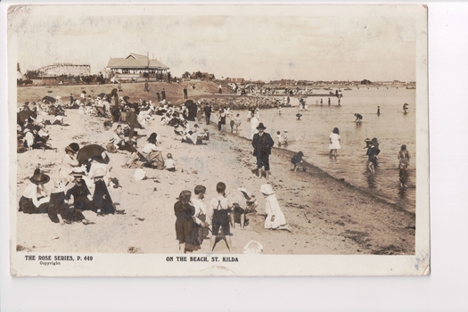 Postcard with a sepia coloured photograph of families on the beach and in the water at St Kilda beach 