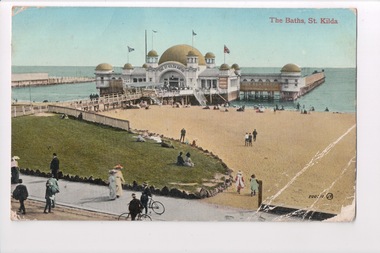 Colour postcard with a photograph of the beach and pier leading to building over water (St Kilda Baths) 