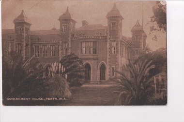 Postcard of sepia photograph of large building with turrets with large shrubs in foreground