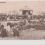 Postcard of sepia image of well dressed people lining roadway with horse and buggies in foreground