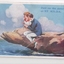 Colour postcard with drawing of a young male/female couple sitting on a rock jutting out over water.