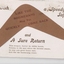 postcard with a brown boomerang attached in centre and written messages on a white background.  