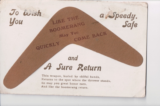 postcard with a brown boomerang attached in centre and written messages on a white background.  