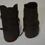 Dark brown leather curved to leg shape, with leather straps and buckles.