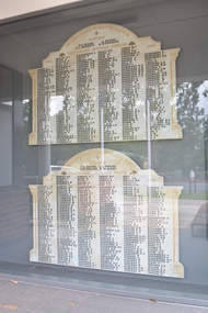 Irregular shaped marble honour roll with carved side columns and in between there are six columns of names in black