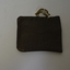 Small brown leather pouch with string attached at one side.
