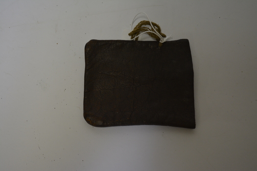 Small brown leather pouch with string attached at one side.