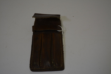 Home made tan leather pen case for three pens.  Has large yellowing stitching.