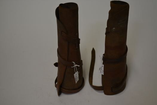 Pair of tan leather  leggings.  Has one long leather strap from calf to ankle which winds around the leg.  
