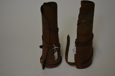 Pair of tan leather  leggings.  Has one long leather strap from calf to ankle which winds around the leg.  
