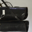 Pair black leather leggings.  Has long leather strap that winds around leg from calf to ankle.  Both leather straps have buckles.