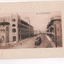 Building lined street with tram in foreground 