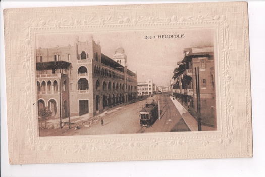 Building lined street with tram in foreground 