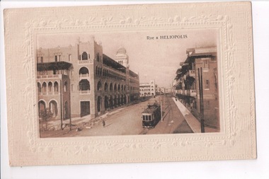 Building lined street with tram in foreground 