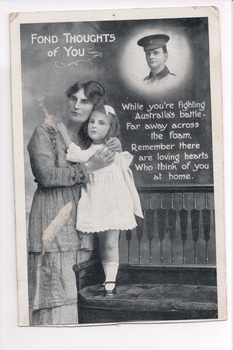 Woman holding child standing on chair with face of soldier top right of black and white postcard