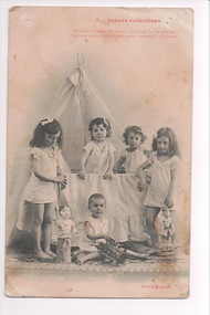 Four children standing two inside a cot and another child sitting on floor