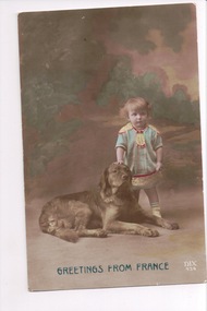 Small child standing next to dog lying down with background of green trees