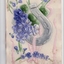 Plastic postcard showing purple flowers and lucky horseshoe with paper backing 